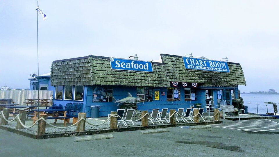 Seafood plates beside wide waterfront windows.